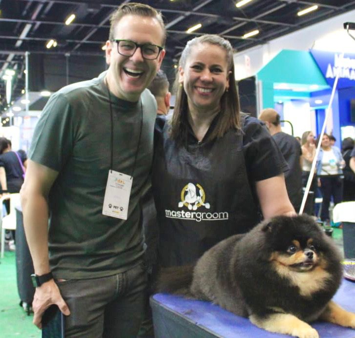 Celso Zucatelli entregando o prêmio Paçoca para a Guga; Spitz na mesa de grooming — evento Mastergroom